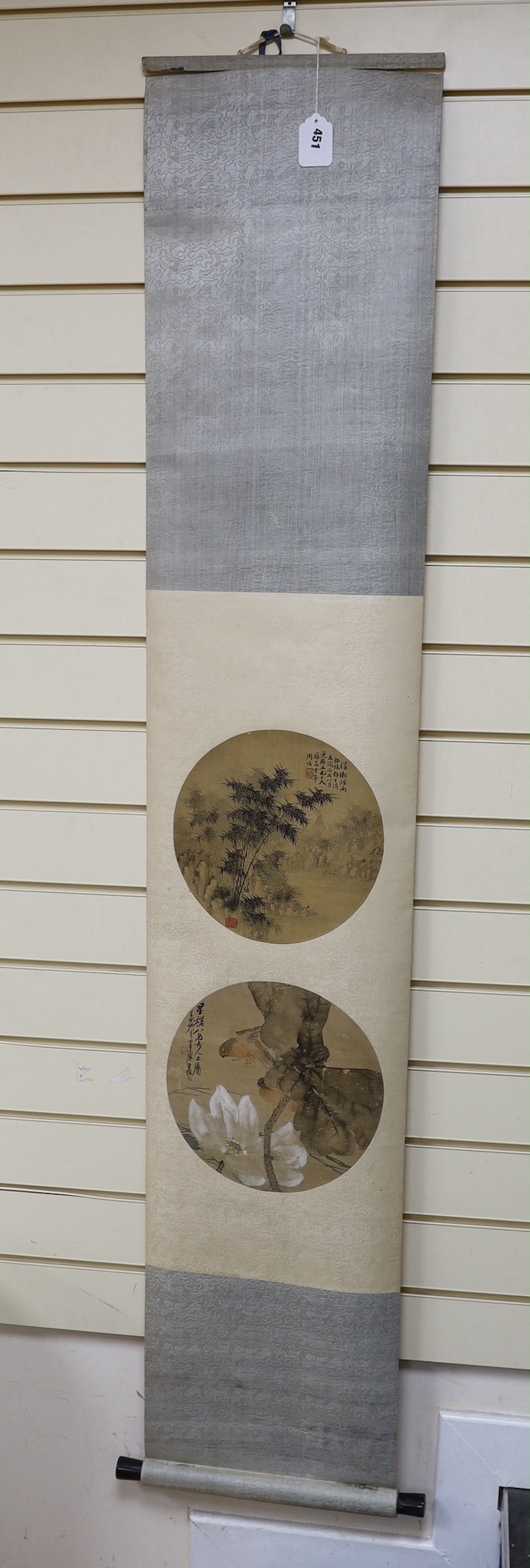 Two Chinese painted and inscribed fan panels on silk, late Qing dynasty, mounted on a scroll, panels 25cm diam.